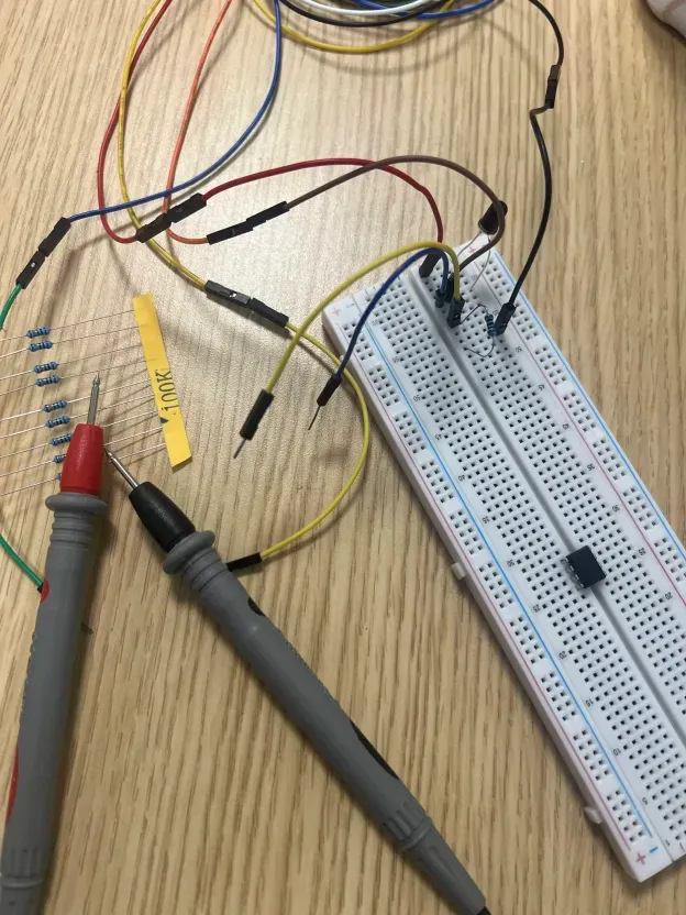 Breadboard with photodiode circuit and multimeter probes
